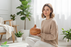 Woman holding Veluné Aura Calm Mist Diffuser in bright minimal space