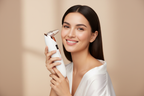 Woman holding Veluné Aura Pore Clean Vacuum with radiant skin