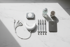 Veluné Aura LED Teeth Whitening Kit components flat lay on white marble
